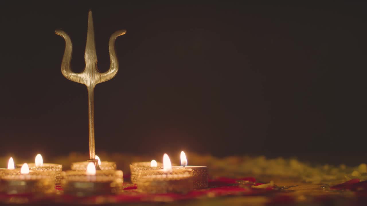 Metal Trishula Statue Divine Trident Symbol Of Hinduism On Decorated Table With Tea Lights Blown Out