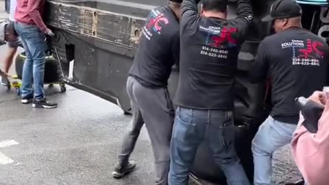 Many people work together to carry the racing car and get ready for the race.