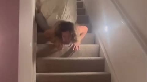 chick face plants trying to ride a cushion down the stairs