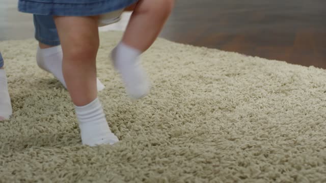 A Mother Teaching Her Baby To Walk