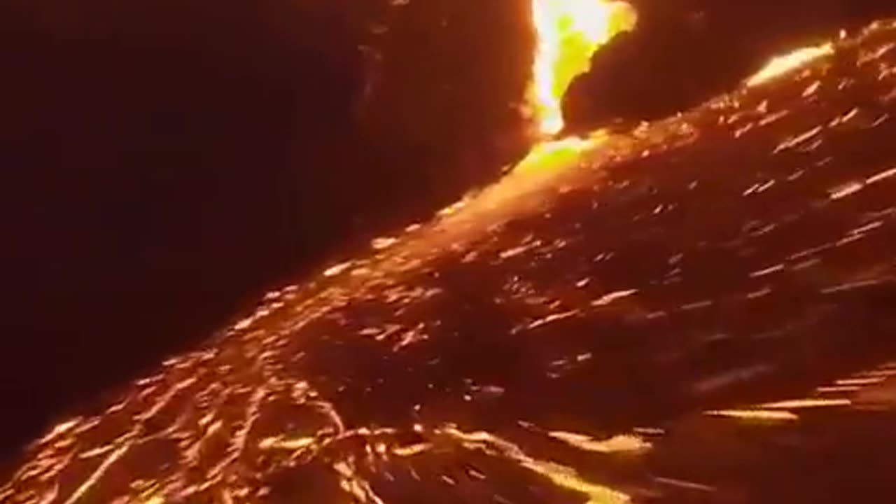 Incredible drone footage flying over a volcano and lava flows at night, captured by