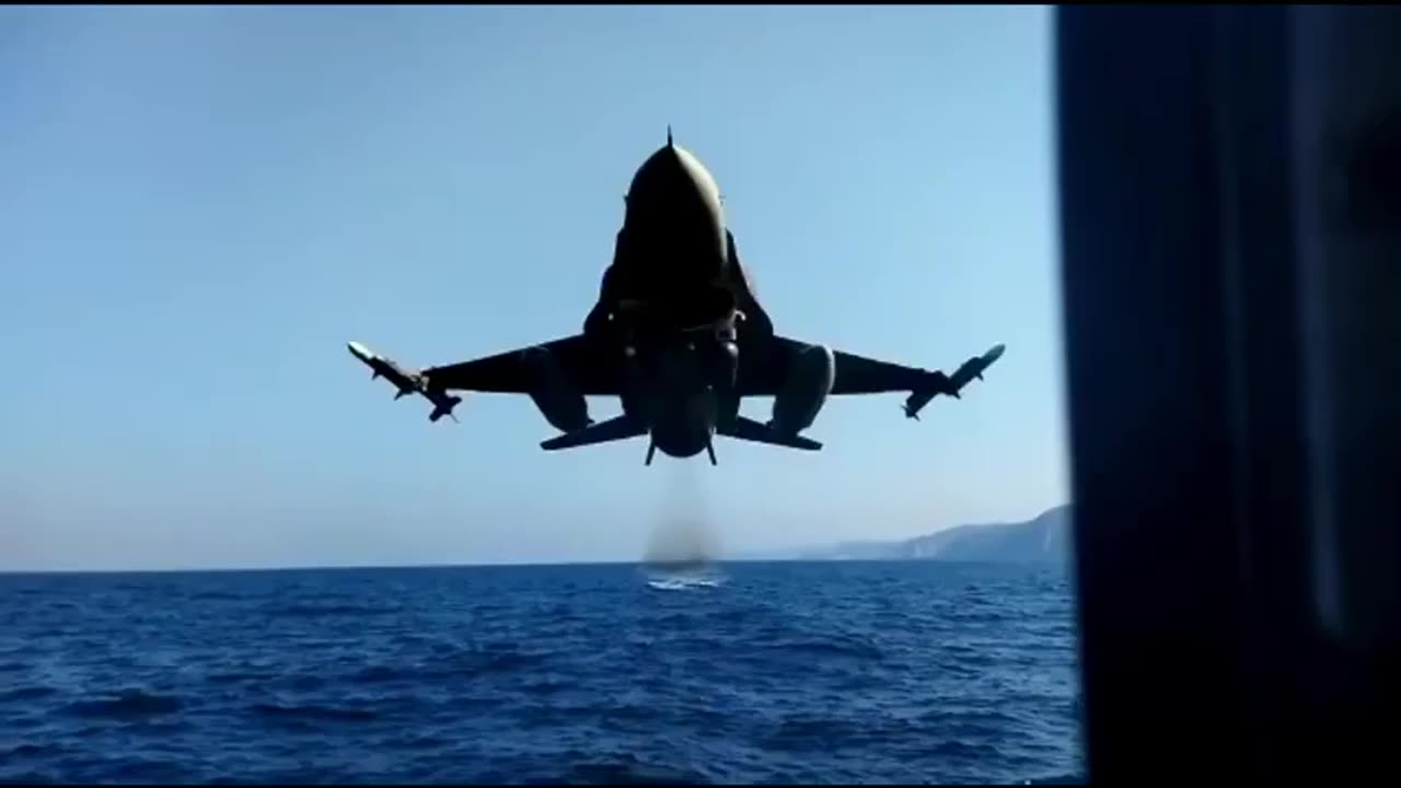 Turkish Air Force F-16 fighter jet passing at extremely low altitude over the sea.