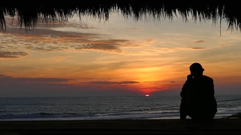 Man Watching a Sunset at a Tropical Beach