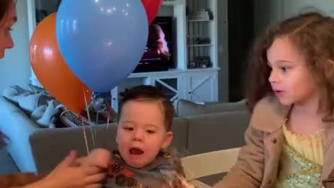 Excited baby uses his hand to put out birthday candles