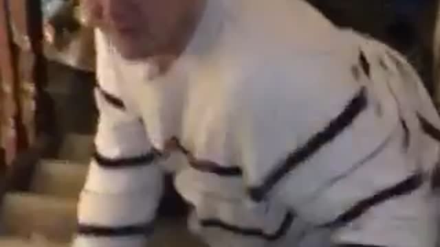 Striped white shirt guy tries to climb stairs and slides down it on back