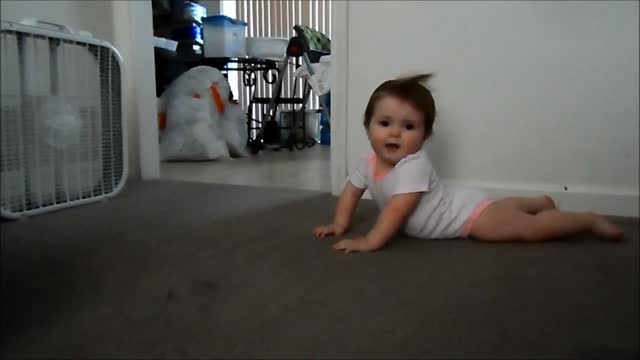 Baby poses for the camera in front of blowing fan like a supermodel