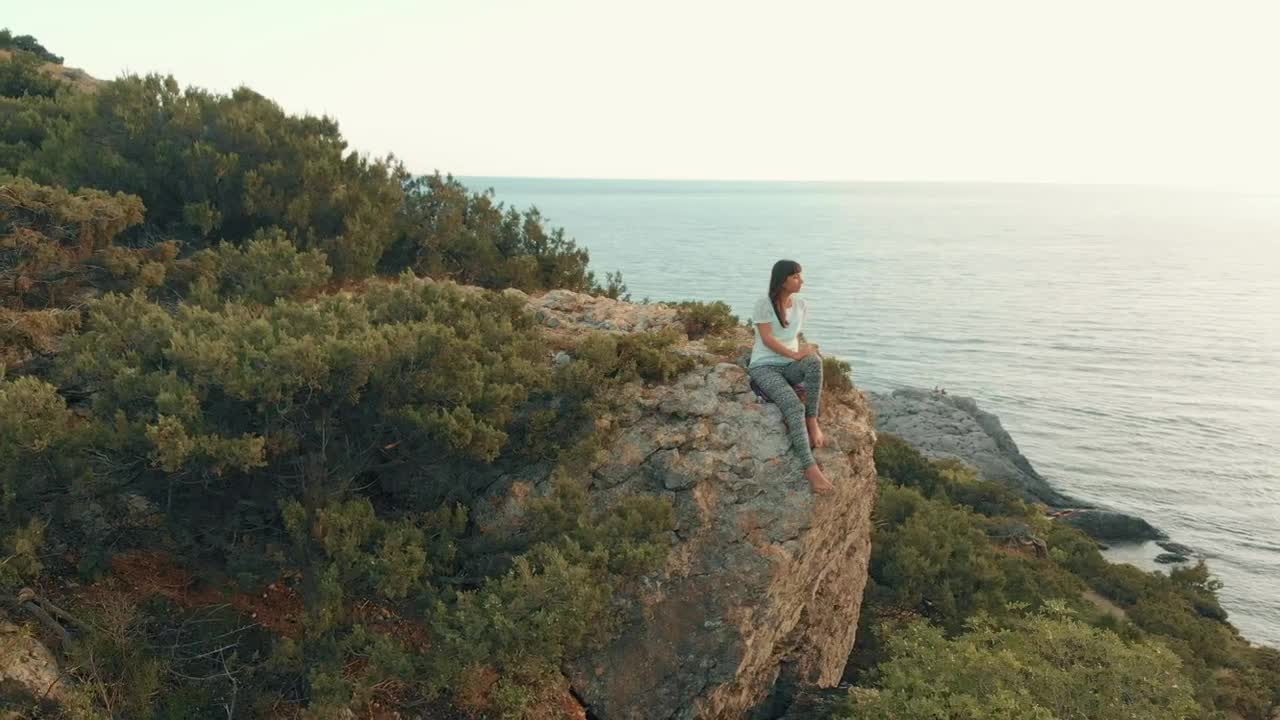 Woman admiring the sea from a cliff