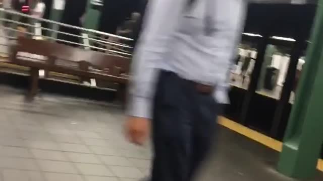 A man in army vest singing in subway station