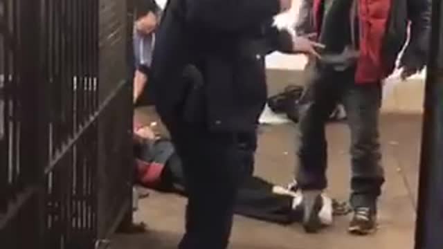 Cop fighting homeless people one falls on tracks