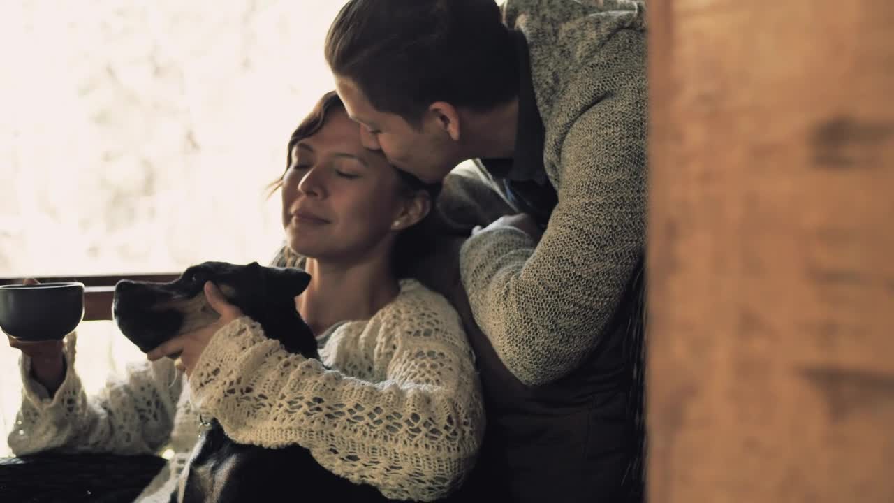 Woman sitting on couch petting dog