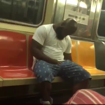 Two guys on train one dancing in seat one falling asleep