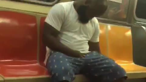 Two guys on train one dancing in seat one falling asleep