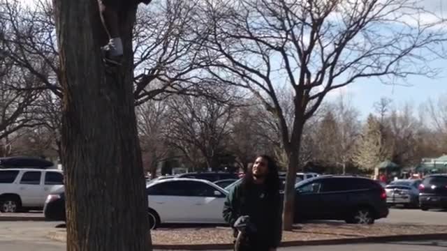 Orange shirt guy attempts backflip off tree lands on side