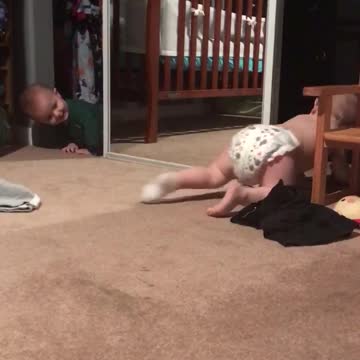 Giggling Twin Baby Brothers Chase Each Other Around A Mirror