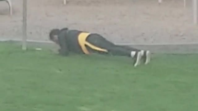 Guy doing planks pushups pelvic thrusting grass playground