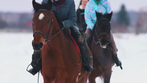 Three women riders riding horses in a village