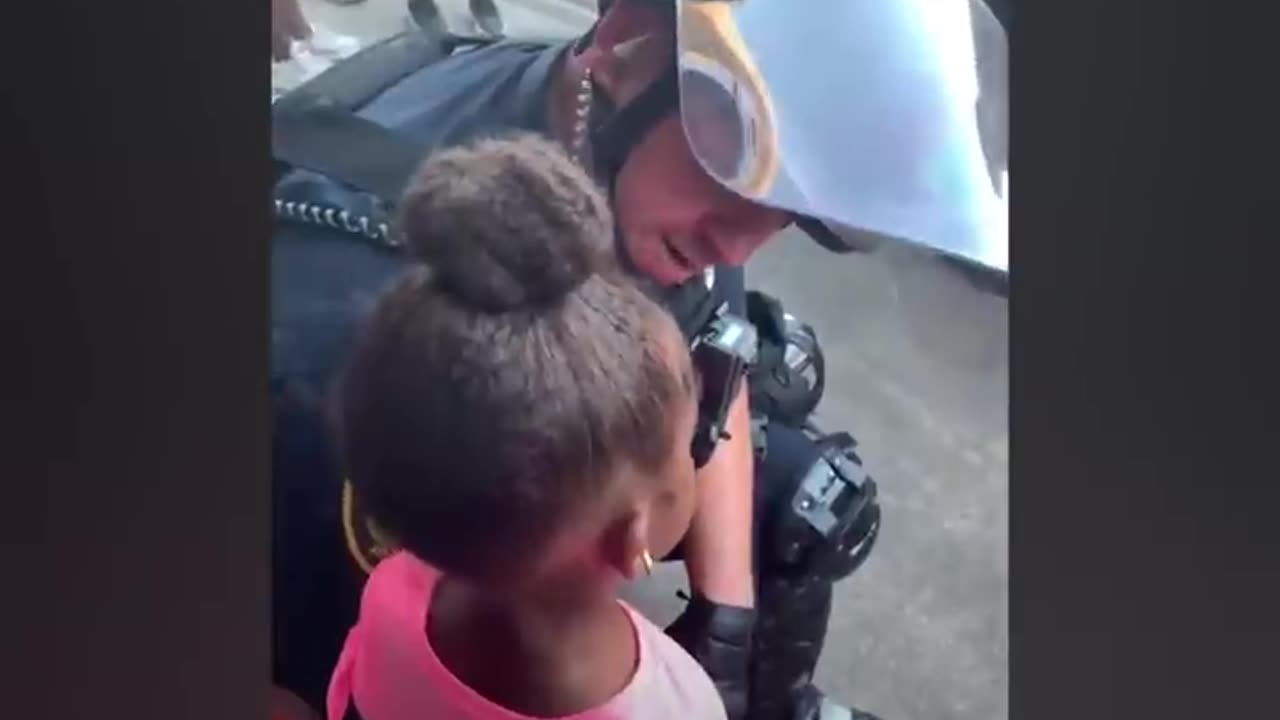 Police officer comforts little girl after she asks: 'Are you going to shoot us?'