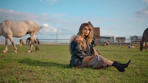 Pleased woman relaxing in horse enclosure