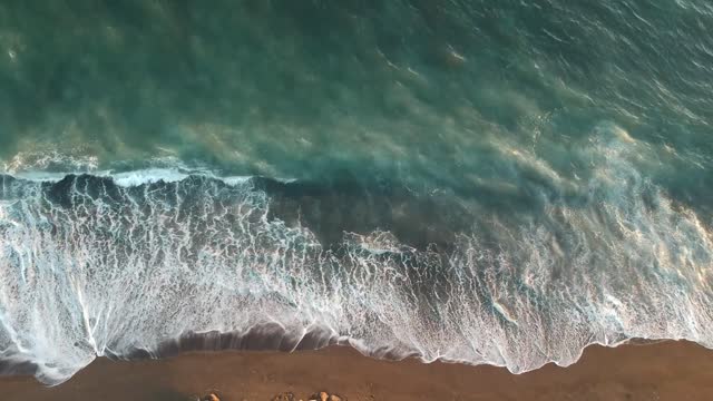 Azure waves wash over the sand of the Pacific beach