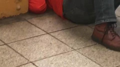 Woman red shirt laying on subway floor