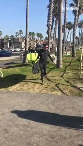 Bunch of guys with surfboards walk to beach