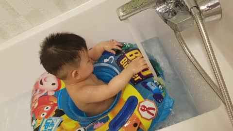 This is a video of a baby playing happily in the bathtub.