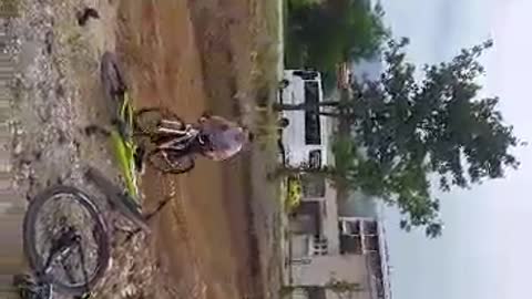 Guy in grey shirt riding bike faceplants on ground