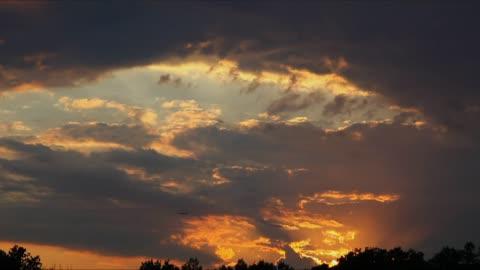 Plane flying across the sky at sunset