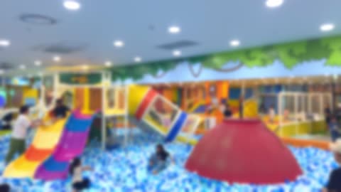 Children and parents having a great time at playplace, blured