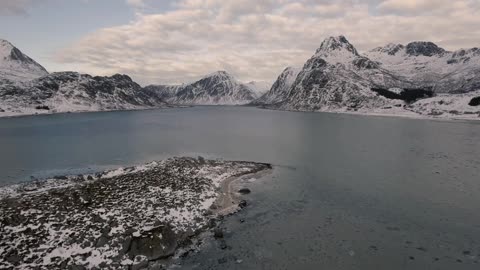 Frozen lake next to snow-capped mountains