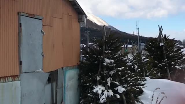 MAN JUMPS OF ROOF INTO SNOW SLOW MOTION