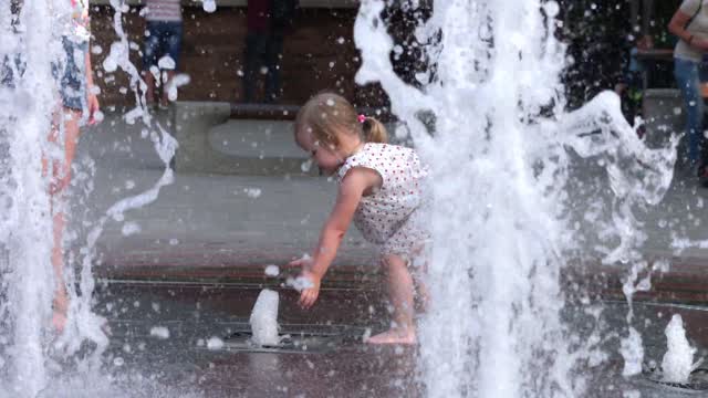 Girls play in the shower in the pool and are very happy
