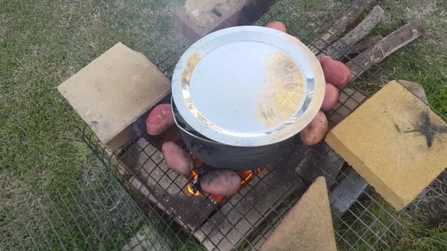 Cooking lentils and tomatoes on woodfire at home