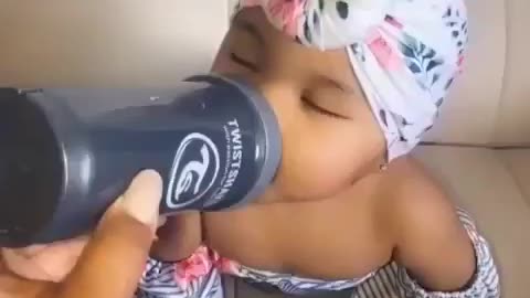 Baby gets her milk while falling asleep and she's cute