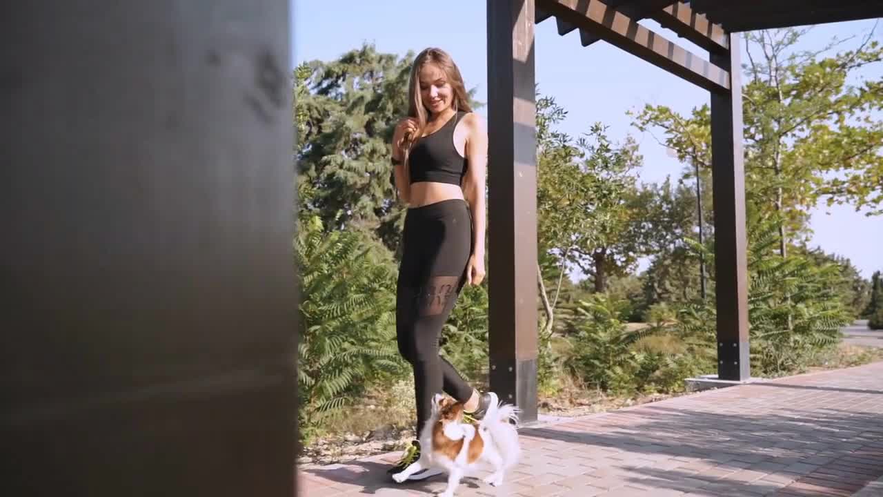 Young adult girl spending weekend day together with little dog