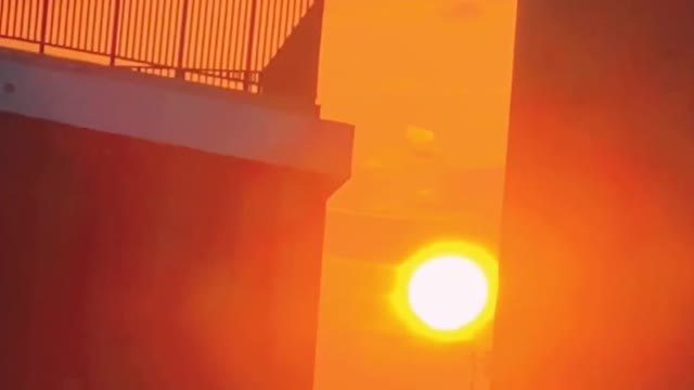 Red sun between tall buildings