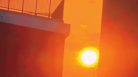 Red sun between tall buildings