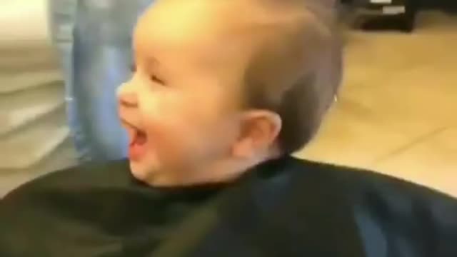 little boy having fun while getting haircut