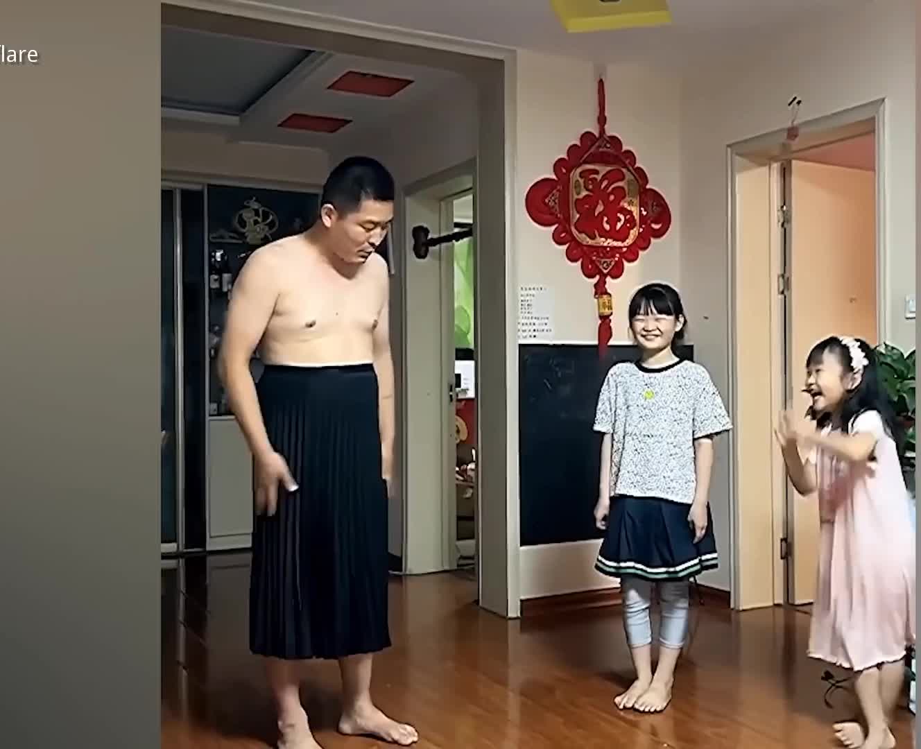 Chinese father puts on dress to show daughters proper way to behave
