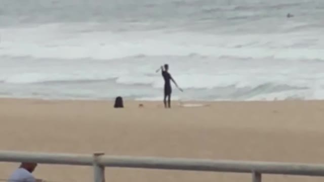 Man in wet suit play with nunchucks