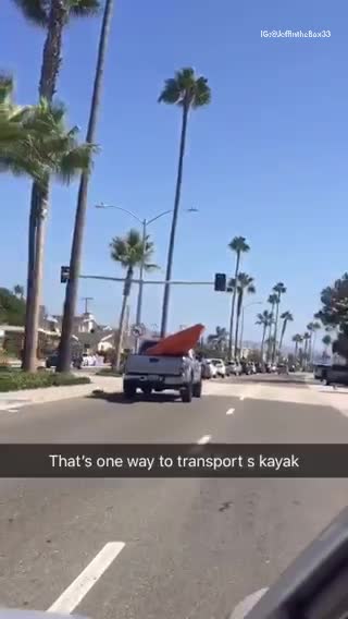 Giant orange kayak in grey truck