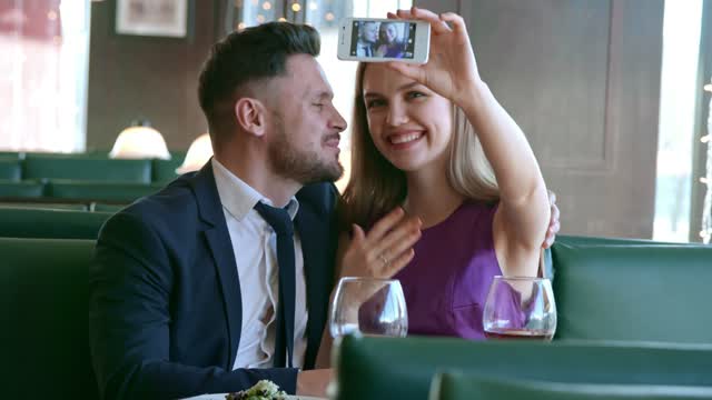 An Engaged Couple Taking A Video Of Themselves Using A Smartphone