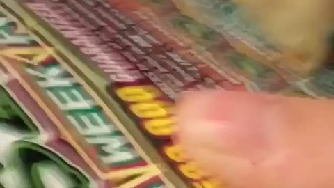 Woman scratches her lottery ticket with a piece of tortilla