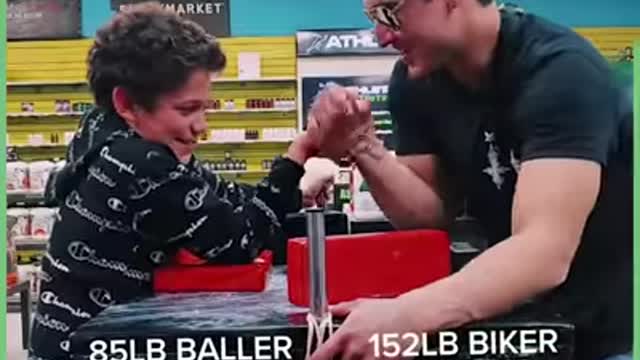 This ripped biker offers big cash for anyone who can beat him in an arm wrestle.