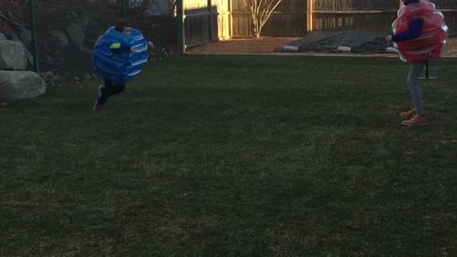 Dad and son wear blue and red bounce suits fall down running at each other