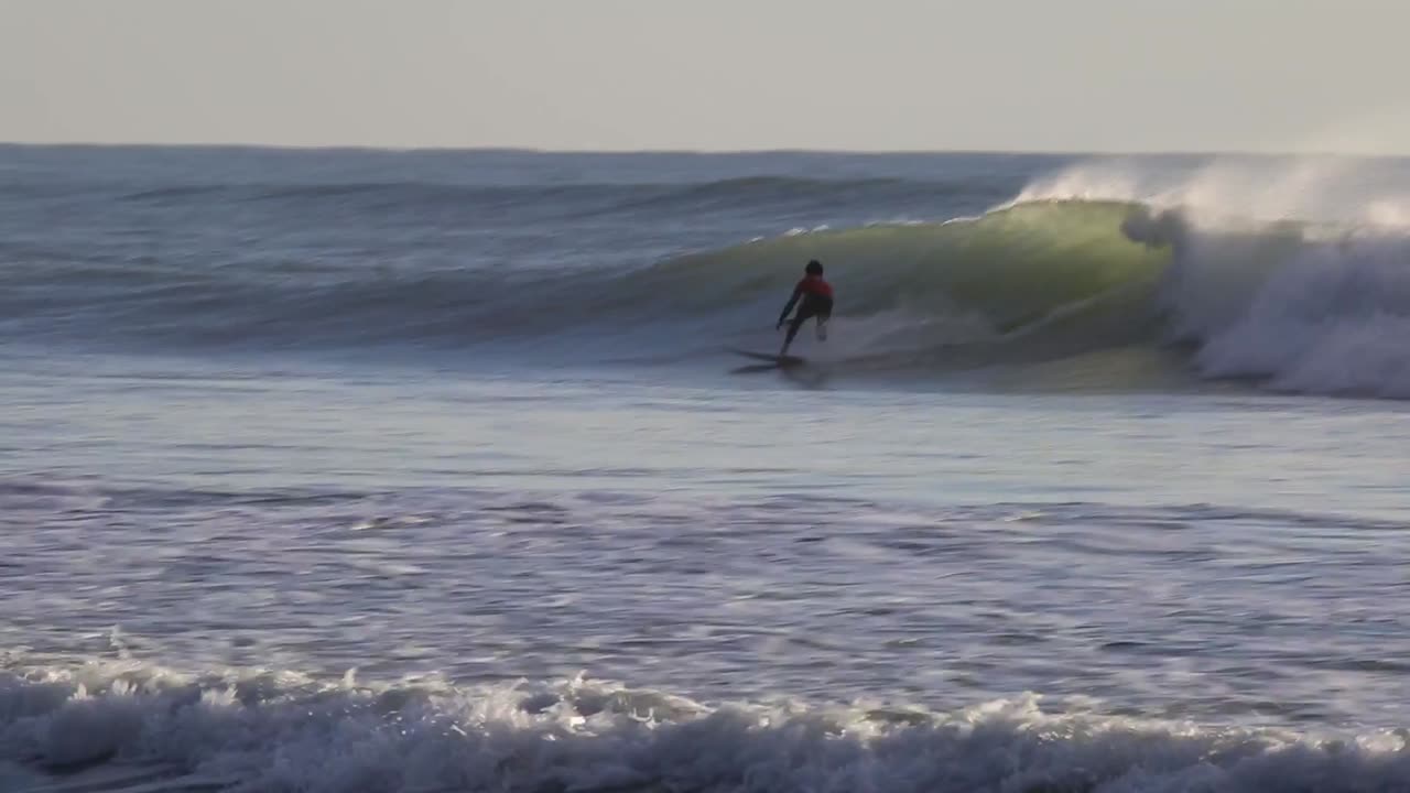 Surfers riding Atlantic Ocean waves at Cabedelo, Viana do Castelo, Portugal in January 2024