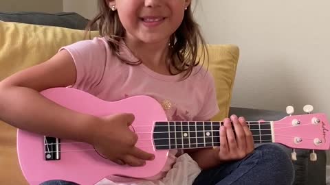 Five year old giving ukulele lesson