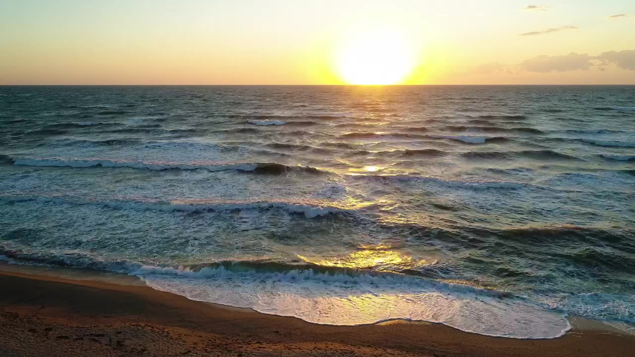 Waves in the sea from a beach during a sunset