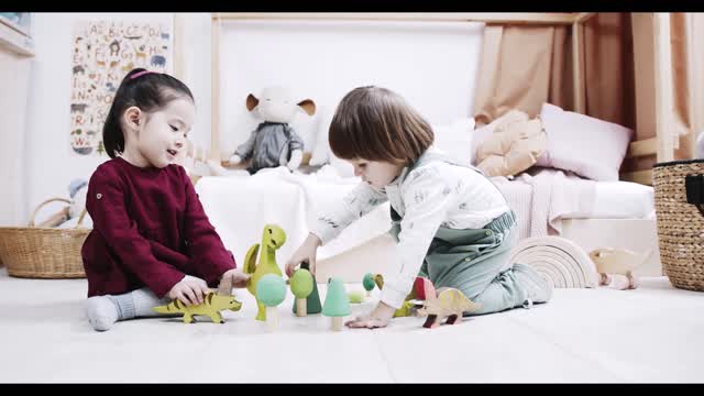 Two Little Kids Playing Wooden Toys On The Floor