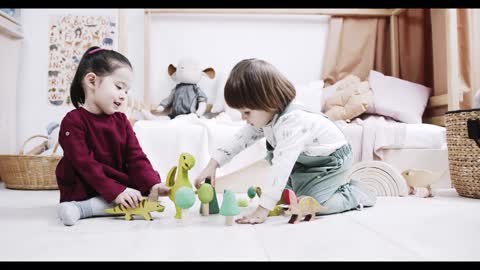 Two Little Kids Playing Wooden Toys On The Floor